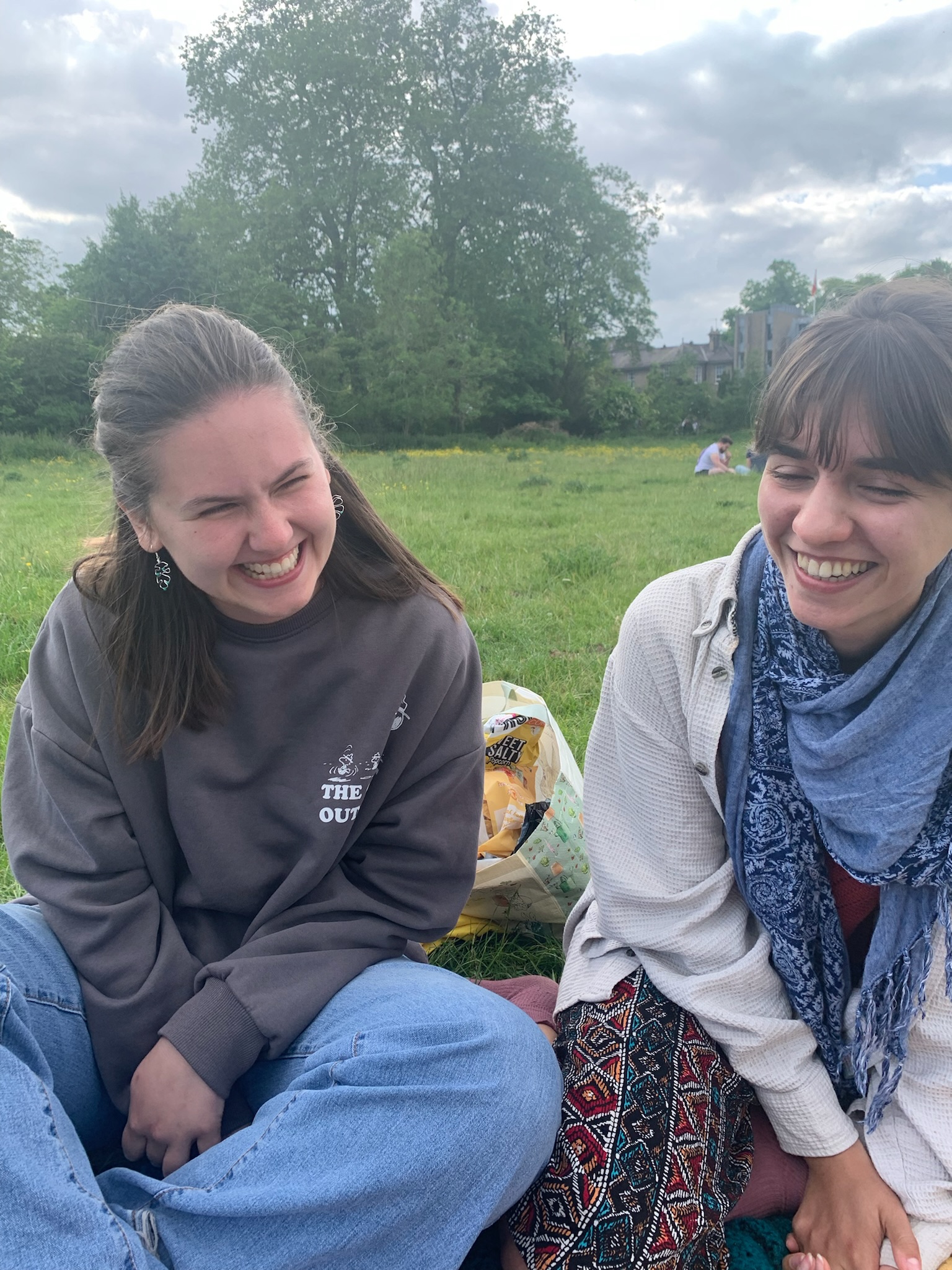 two friends laughing, wearing up-cycled earrings